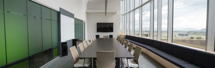 Meeting room with a long table and a wall of windows.